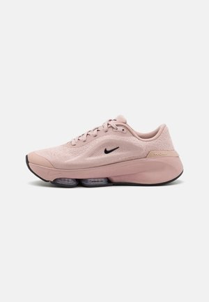 Světlé růžové běžecké boty Nike s síťovaným svrškem, černým logem Swoosh, polstrovanou podrážkou a průhlednými vzduchovými kapslemi ve střední podrážce.