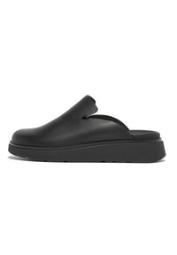 Black leather slip-on shoes with a rounded toe and cutout detail, featuring a thick black rubber sole and smooth texture.