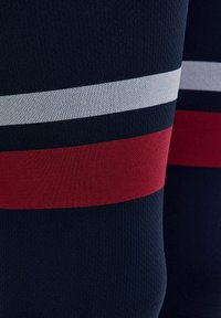 Granatowe spodenki sportowe z czerwonymi, szarymi i białymi poziomymi paskami. Gładka tekstura z lekkim, oddychającym materiałem.