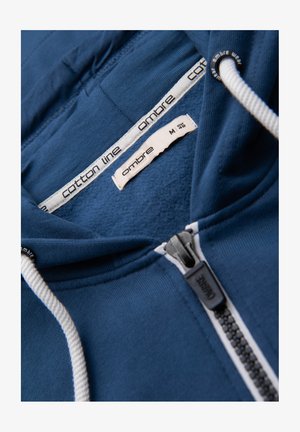 Blue cotton hoodie with white drawstrings, black zipper, and size tag marked M EUR 48 from Ombre Cotton Line.