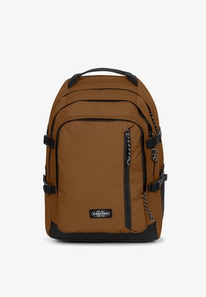Bruine stoffen rugzak met zwarte accenten, meerdere compartimenten, verstelbare banden en een bovenhandvat. Voorzien van ritsen en een logopatch.
