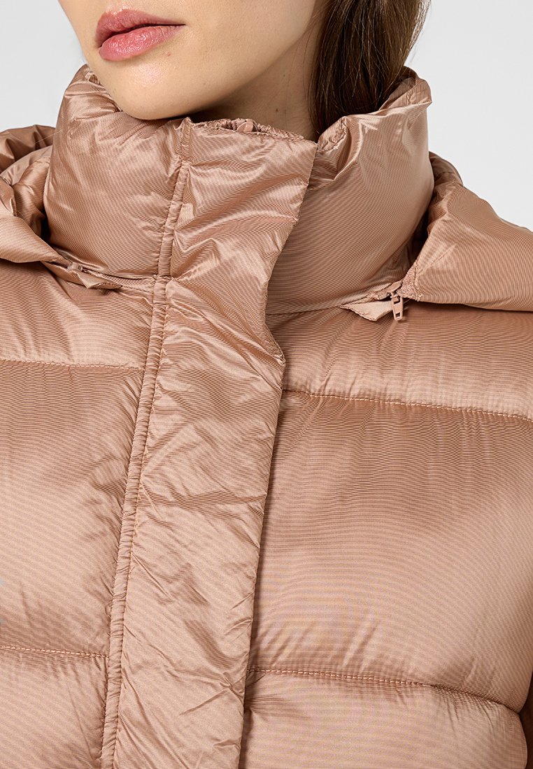 Jasnoróżowa kurtka puchowa z wysokim kołnierzem, poziomym przeszyciem oraz gładką, błyszczącą teksturą z subtelnym wzorem w paski.