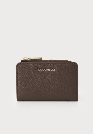 Brown leather wallet with a textured surface, gold hardware detailing, and a zip closure, featuring the brand name embossed on the front.