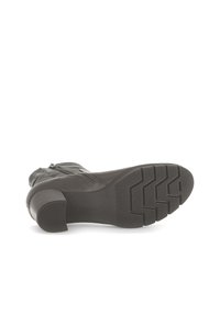Zwarte leren enkellaars met een stevige grijze rubberen hak en profielzool, voorzien van een ritssluiting aan de zijkant en contrasterende stiksel details.