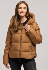 Brązowa kurtka puchowa z dużym, miękkim kapturem, zapinana na zamek z przodu oraz bocznymi kieszeniami. Teksturowany, pikowany design z luźnym krojem.