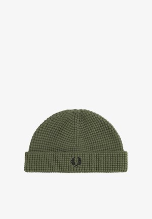 Berretto lavorato a maglia verde con una texture a costine, dotato di un risvolto e di un piccolo logo nero ricamato sul lato.