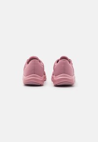 Scarpe sportive rosa con tomaia in rete, collare imbottito e suola in gomma testurizzata. La vista da dietro evidenzia curve morbide e cuciture uniformi.