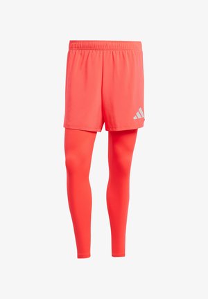 Red athletic shorts with elastic waistband layered over matching red leggings. Features a small silver logo on the shorts' side.