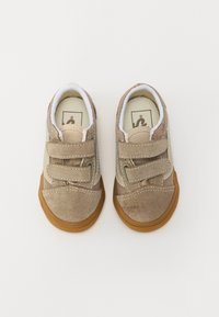 Chaussures pour tout-petits en daim marron avec des sangles Velcro, une semelle en caoutchouc et une doublure blanche. Présente des accents beige et des coutures contrastées.