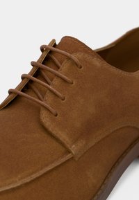 Καφέ σουέτ παπούτσι με κορδόνια, με απαλή υφή, που διαθέτει δομημένο άνω μέρος, διακριτές ραφές και στρογγυλά κορδόνια σε σχέδιο στρογγυλής μύτης.