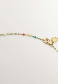 Pulsera de cadena de oro que presenta cuentas coloridas en blanco, rosa, amarillo, turquesa y un cierre de langosta con un detalle de charm circular.