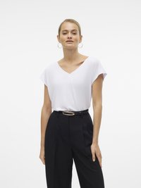 Top alb cu decolteu în V și mâneci scurte, asortat cu pantaloni negri cu croială elegantă și o curea lată cu o cataramă ovală aurie.