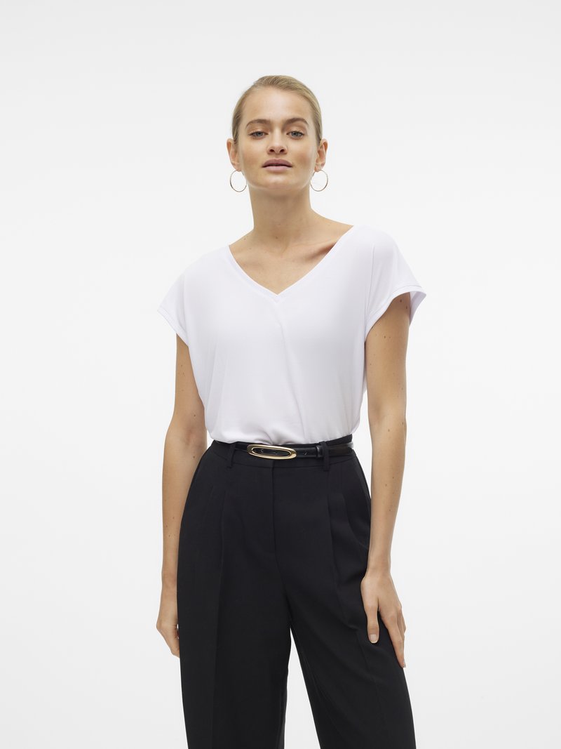 Top alb cu decolteu în V și mâneci scurte, asortat cu pantaloni negri cu croială elegantă și o curea lată cu o cataramă ovală aurie.