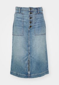 Jupe en denim bleu clair. Présente un devant à boutons, deux grandes poches avant et une fente centrale à l'ourlet. Forme classique évasée.