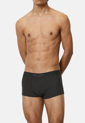 Schwarze Boxershorts für Männer mit geripptem Material, ausgestattet mit einem breiten Bund, der mit "Marc O'Polo" beschriftet ist. Die Passform ist körperbetont und kurz.