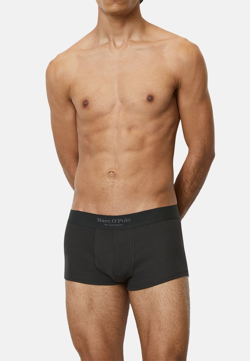 Schwarze Boxershorts für Männer mit geripptem Material, ausgestattet mit einem breiten Bund, der mit "Marc O'Polo" beschriftet ist. Die Passform ist körperbetont und kurz.