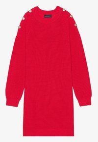 Robe en maille rouge avec manches longues, texture côtelée et boutons décoratifs aux épaules. Encolure ronde et coupe décontractée.
