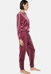 Fluweel loungewear set in diep bordeauxrood, bestaande uit een sweatshirt met ronde hals en joggers met elastische tailleband, geribbelde boorden en zijzakken.