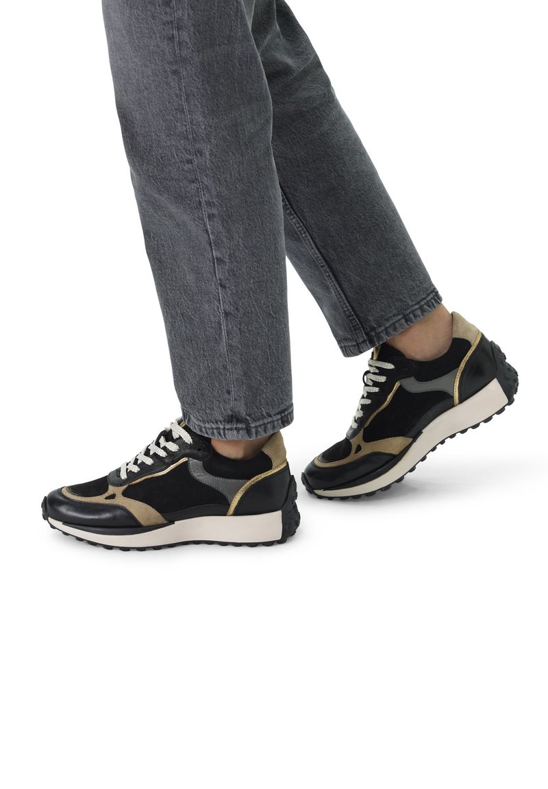 Zwart-gouden sneakers van leer en suède, met een ronde neus, gestructureerde zolen en contrasterende accenten aan de zijkanten.