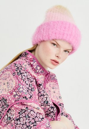 Gorro de malha em ombre rosa com uma textura felpuda. Casaco acolchoado floral em tons de rosa e roxo com padrões detalhados.