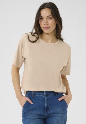 Beige short-sleeve t-shirt with a round neckline, made of soft fabric, paired with blue denim jeans. Casual fit, smooth texture.