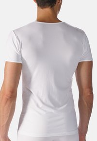 Witte t-shirt met korte mouwen, gemaakt van soepel katoenen materiaal met een aansluitend ontwerp. Beschikt over een ronde halslijn en een naadloze schouderconstructie.