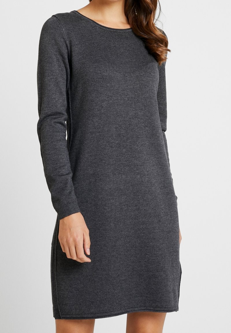 Robe tricotée gris foncé avec des manches longues, un col rond et des fentes sur les côtés au niveau de l'ourlet. Texture lisse, coupe décontractée et poignets côtelés.