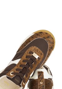 Brown and white athletic sneakers featuring a mix of smooth and fur-textured materials, contrasting laces, and a gold logo accent.