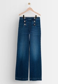 Tummat pesu wide-leg farkut, joissa on korkea vyötärö ja viisi pronssista nappia edessä. Pehmeä rakenne vähäisellä haalistumisella.