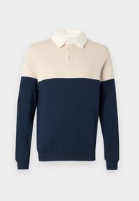 Πόλο μπλούζα σε συνδυασμό χρωμάτων εκρού και ναυτικού μπλε. Διαθέτει γιακά, τρία κουμπιά και ριμπ μανσέτες. Λείο βαμβακερό ύφασμα.