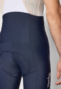 Pantalones cortos de ciclismo en color navy, hechos de material elástico. Cuentan con un asiento acolchado para mayor comodidad y un logo blanco en el costado. Textura suave.