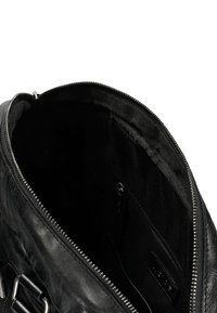 Borsa in pelle nera con texture liscia, dotata di apertura con zip, fodera in tessuto scuro e una tasca interna con zip.