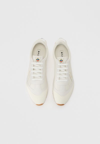 Valged tennisereid, mille ülemine osa on tehtud nahast, kergete aktsentidega, ümmarguse varbaga, lamede paeltega ja kummi kummist tallaga. Bally logo keelal.