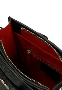 Interno della borsa in pelle nera con una foderatura rossa, una tasca con zip e accessori in metallo dorato. Design strutturato con più scomparti.