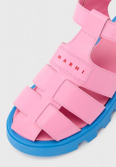 Ροζ δερμάτινο σανδάλι με πολλαπλά λουράκια και το λογότυπο "MARNI" σε κόκκινο στο πάνω λουράκι, με χονδρό μπλε πατάκι από καουτσούκ.