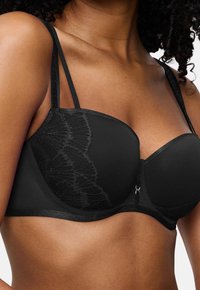 Μαύρο σουτιέν με δαντελένιες λεπτομέρειες, λείες θήκες, ρυθμιζόμενες τιάρες και κλείσιμο με γάντζο. Περιέχει υφή στο πλάι.