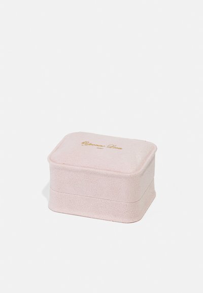 Ružová obdĺžniková šperkovnica z mäkkého textúrovaného materiálu s gold zasadeným logom na veku. Hladké, zaoblené okraje, kompaktný dizajn.