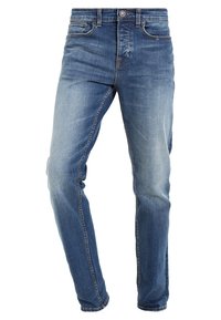 Jean en denim bleu slim avec légère décoloration sur les cuisses et les genoux, doté de poches avant, passants pour ceinture et fermeture par bouton.