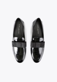 Czarne lakierowane loafersy z szeroką kokardą z przodu oraz małym logo z boku. Gładkie i błyszczące wykończenie.