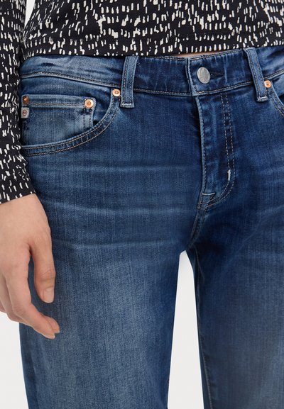 Blugi skinny din denim, într-o nuanță de albastru închis, cu accesorii din cupru, detalii cusute și o textură ușor uzată.