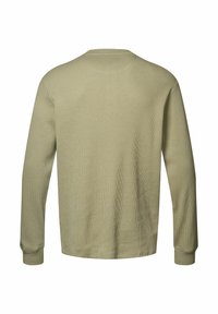 Duga majica s dugim rukavima u prigušenoj zelenoj boji, izrađena od teksturirane vaflaste tkanine. Ima okrugli izrez i uske manšete s ravnim rubom.