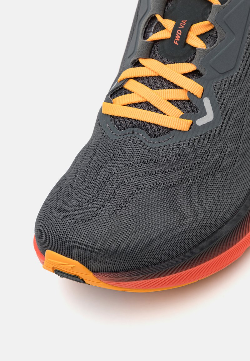 Zapatilla de running con una parte superior de malla negra texturizada, cordones naranjas y una suela con un degradado rojo-naranja. Característica notable del logotipo en el lateral.