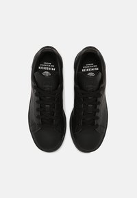 Sorte lædersneakers med perforerede detaljer, flade snørebånd, rund tå og branding på indersålerne. Glat tekstur og minimalistisk design.