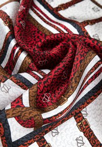 Seidenschal mit einem geometrischen Muster in Rot, Braun und Schwarz. Die zerknitterte Textur zeigt filigrane Designs und kontrastierende Farbblöcke.