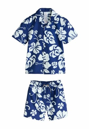 Marineblå kortærmet skjorte og matchende shorts med hvide blomsterprint. Skjorten har krave og knapper; shorts har elastisk taljebånd.