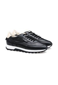 Sneaker in pelle nera con superficie texture, suola intermedia bianca e suola esterna in gomma nera. Presenta un accento sul tallone color crema e lacci.