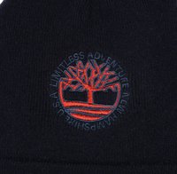Beanie nera lavorata a maglia con un logo ricamato di un albero in rosso e blu, con il testo "UN'AVVENTURA SENZA LIMITI" che circonda il design.
