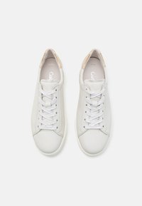 Sneakers bianchi in pelle con punta rotonda, lacci bianchi piatti e un accento di cuoio texturizzato sul tallone. Superficie liscia e design minimal.