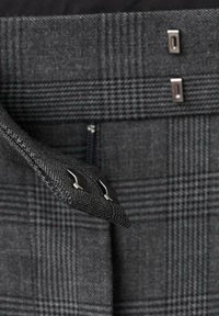 Tejido de patrón gris con un diseño de espiga. Presenta cierres de hardware metálico y una cremallera oculta en la cintura.