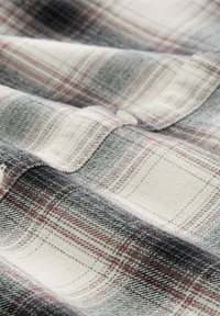 Karierte Flanellhemd in Schwarz-, Weiß- und Rottönen. Verfügt über einen Knopfverschluss, eine weiche Textur und ein markantes Karomuster.